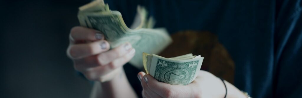 focus photography of person counting dollar banknotes