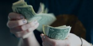 focus photography of person counting dollar banknotes