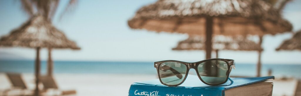 black framed Ray-Ban Wayfarer sunglasses on top of book