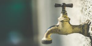 brass faucet with water droplets