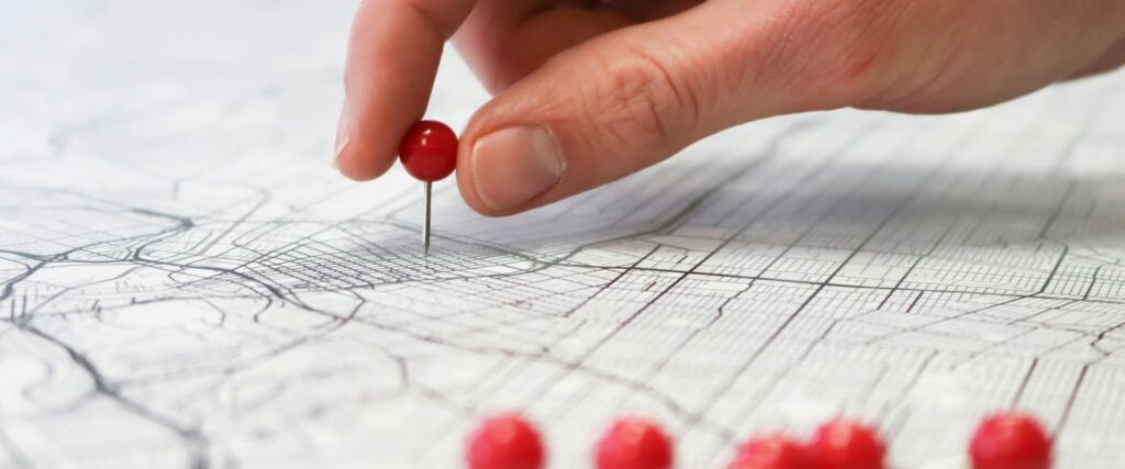 person holding red round medication pill