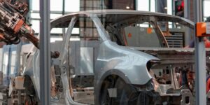 gray vehicle being fixed inside factory using robot machines