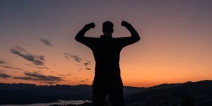 a man standing on top of a bench at sunset